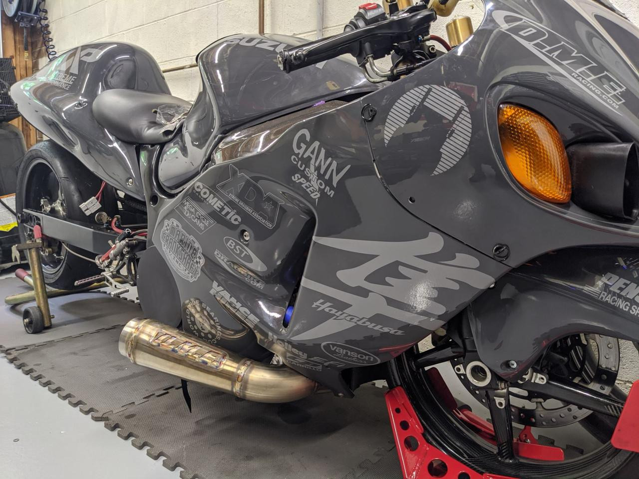 DME Mark1 Sidewinder Exhaust System, motorcycle racing bike with custom exhaust installed in a garage.