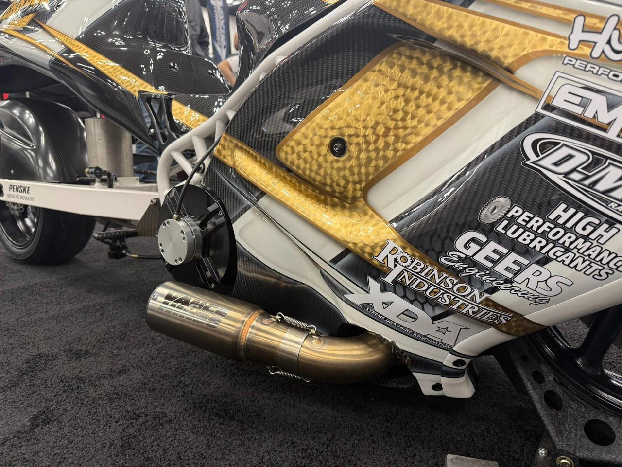 Vance & Hines 4-1 Exhaust System Suzuki Hayabusa (99-25), close-up view showing the metallic exhaust pipe and aerodynamic body with sponsorship decals.