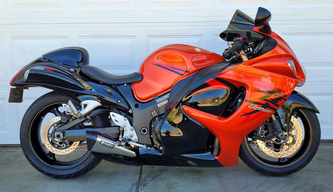 Brocks Performance Brocks Penta-Carbon Full System 15" Muffler Suzuki Hayabusa (99-21), motorcycle with a vibrant red and black body sitting in front of a white garage door. Brocks Performance Brocks Penta-Carbon Full System 15" Muffler Suzuki Hayabusa (99-21), motorcycle with a vibrant red and black body sitting in front of a white garage door.