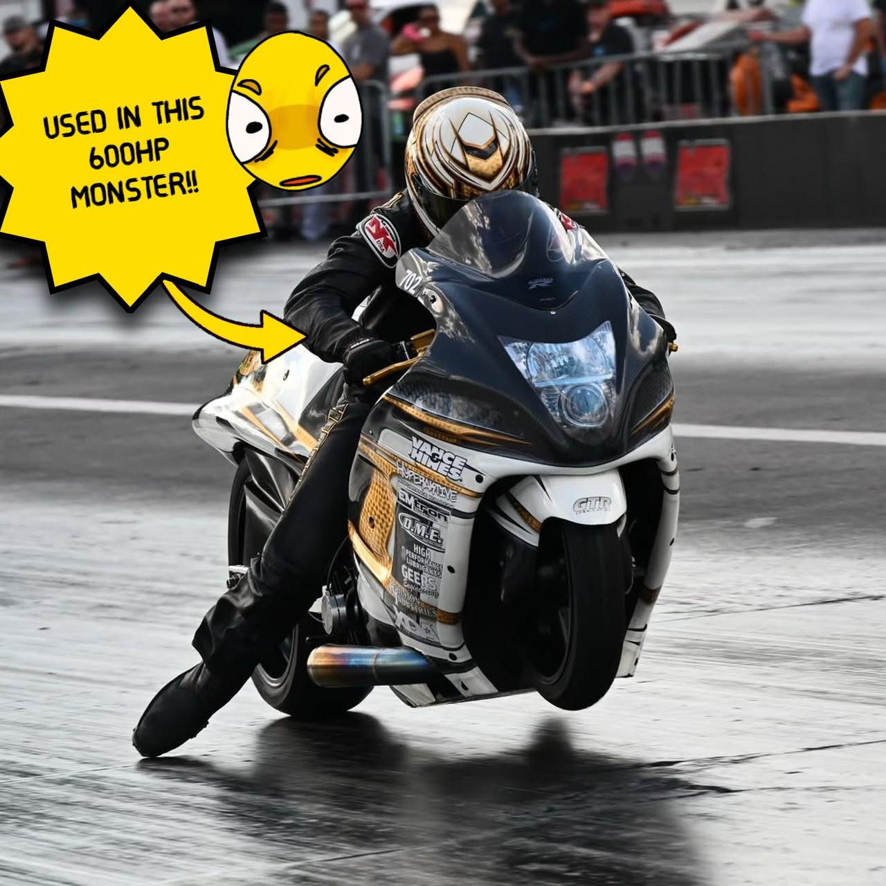 Vance & Hines Front Cam Chain Guide/Rear Tensioner Suzuki Hayabusa (99-26), a motorcycle part used for engine timing and tensioning, mounted on a black and white Suzuki Hayabusa motorcycle during a drag race.