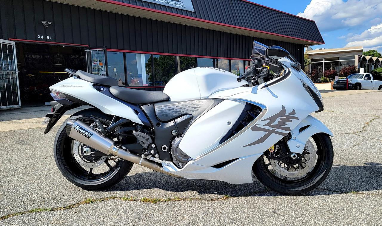 Brocks Performance Brocks CT Full Exhaust 16" Muffler Suzuki GSX1300R Hayabusa (22-25), image of a white Suzuki Hayabusa motorcycle equipped with a Brocks CT full exhaust system, parked outside a shop.