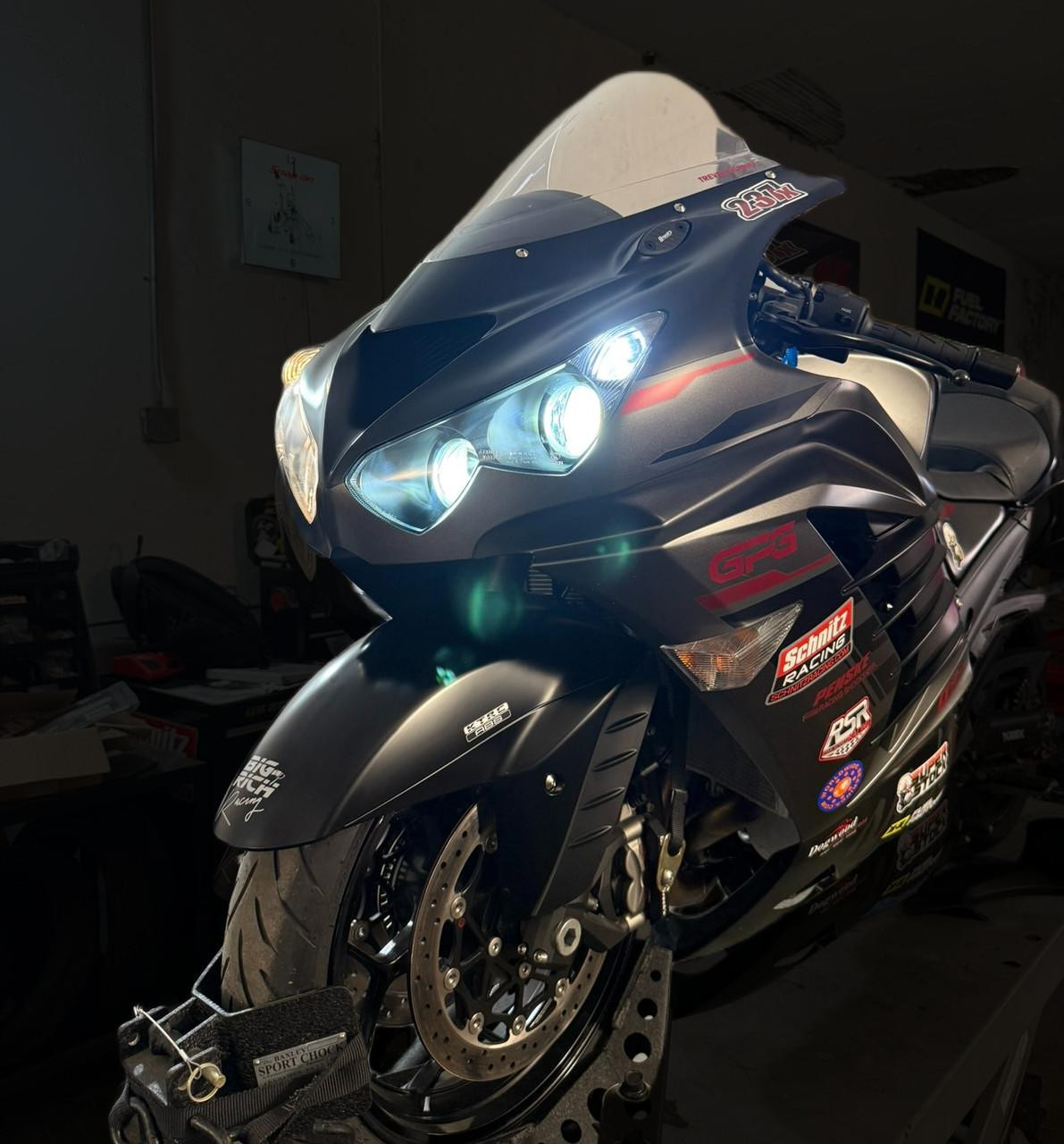 Schnitz Racing Schnitz LED Headlight Upgrade Kit Kawasaki ZX-14R (06-25), focused on the front of a black Kawasaki ZX-14R motorcycle with illuminated headlights, showcasing modern LED headlight upgrade for enhanced visibility and style.