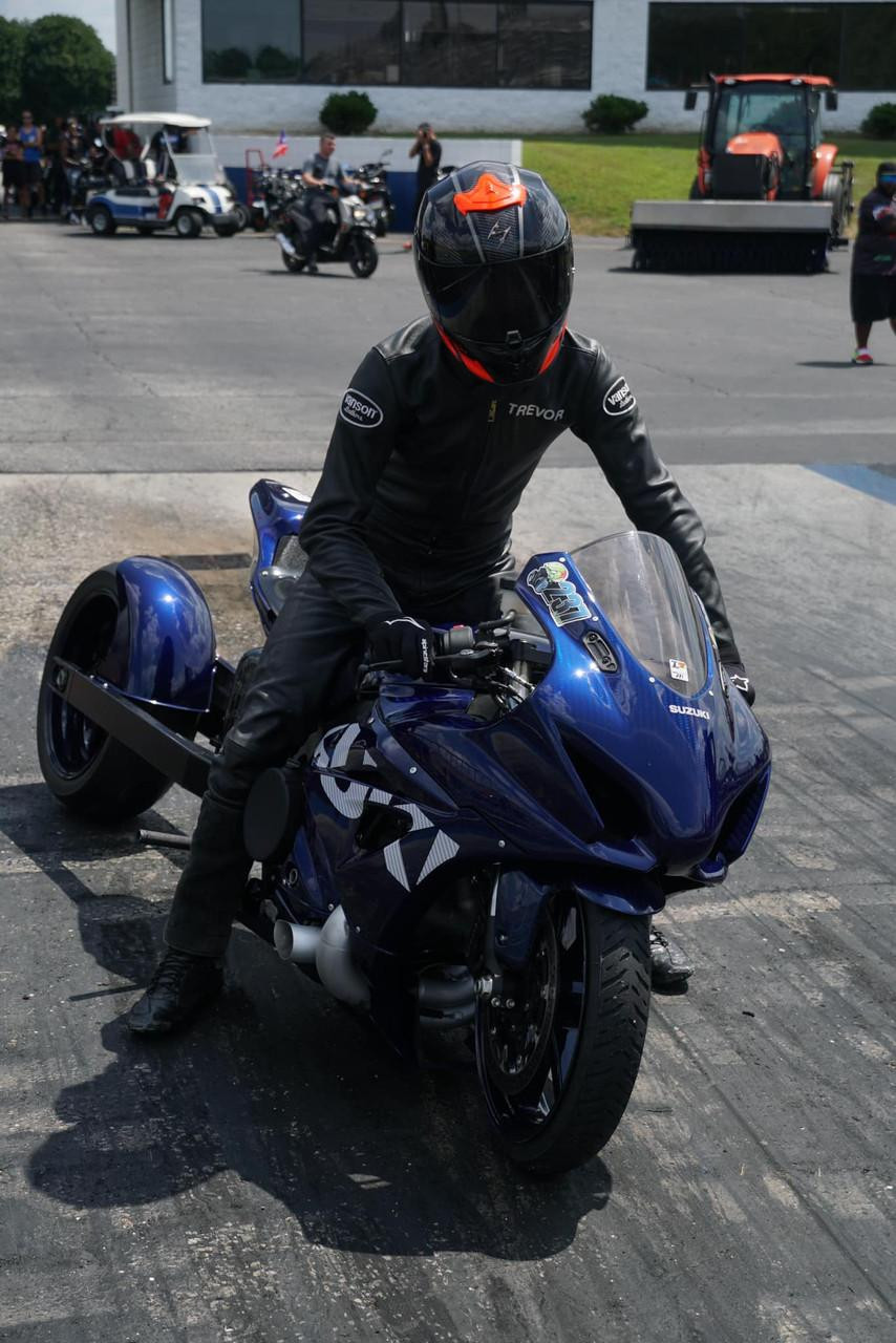 HTP Performance HTP Pigtail Exhaust System for Suzuki GSXR1000 (17-25), blue motorcycle on racetrack with rider in black racing suit and full gear. HTP Performance HTP Pigtail Exhaust System for Suzuki GSXR1000 (17-25), blue motorcycle on racetrack with rider in black racing suit and full gear.