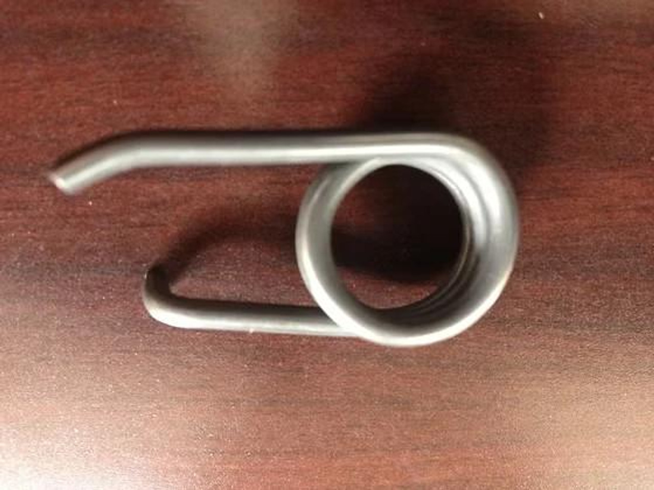 Robinson Industries Heavy Duty Detent Spring Kawasaki ZX-14R (06-26), metallic spring with a coiled design and extended bent arms placed on a wooden surface. Robinson Industries Heavy Duty Detent Spring Kawasaki ZX-14R (06-26), metallic spring with a coiled design and extended bent arms placed on a wooden surface.