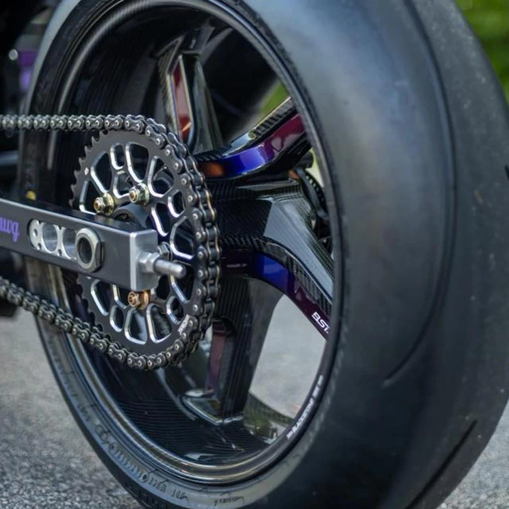 Vortex Motorcycle Parts Vortex V4 Lightweight 520 Rear Sprocket, close-up of the motorcycle rear wheel showing the sprocket, chain, and tire, with emphasis on the high-performance sprocket design and materials.