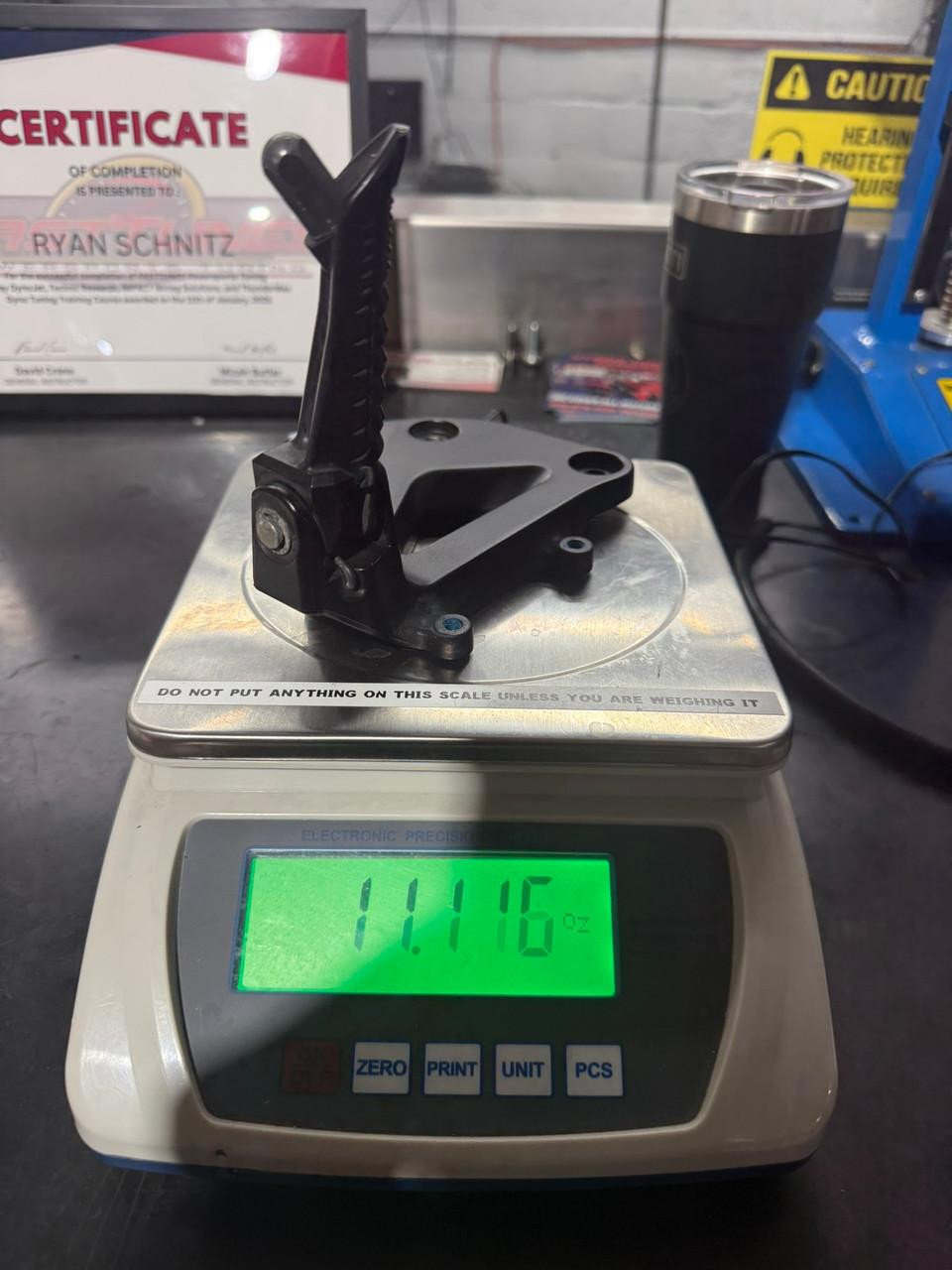 Schnitz Racing Motorcycle Performance Parts Lightweight Rear Sets Suzuki GSXR1000 (17-26), showing a black rear set listed on a digital scale weighing 11.16 oz.