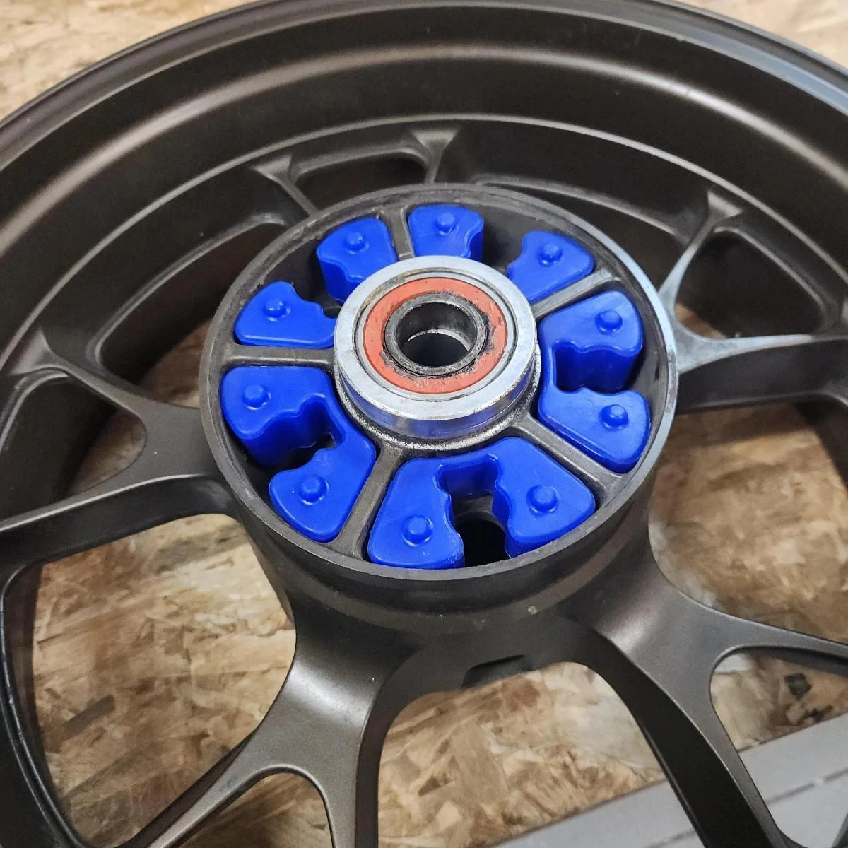VooDoo Motorcycle Components VooDoo Rear Wheel Cush Drive Dampers for Kawasaki H2, close-up of black rear wheel with blue cush drive dampers around central bearing.