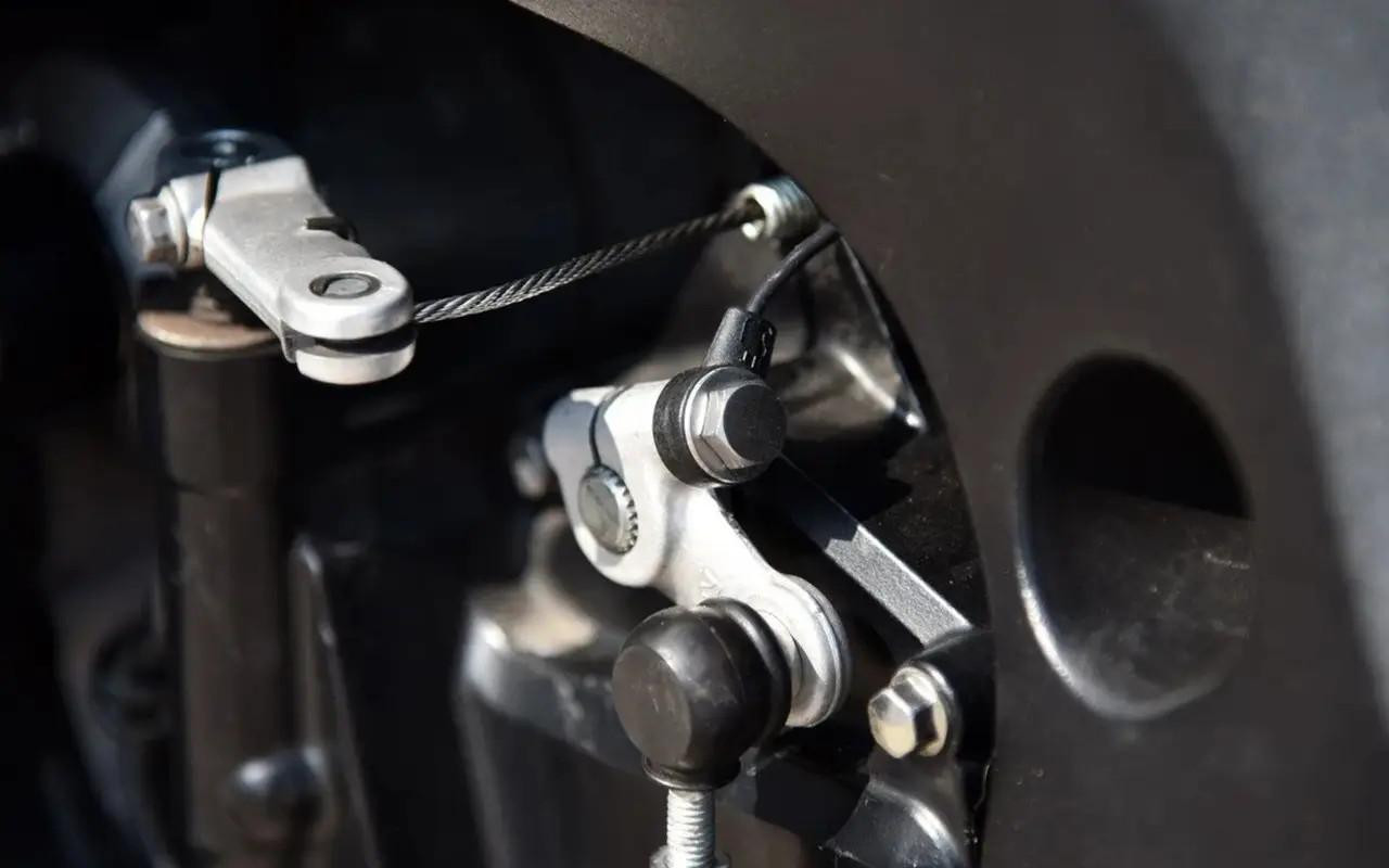 HealTech Electronics Healtech Quickshifter Kit Suzuki GSXR750 (00-26), close-up view of the quickshifter installation on a motorcycle gearbox with metal components and cable connections.