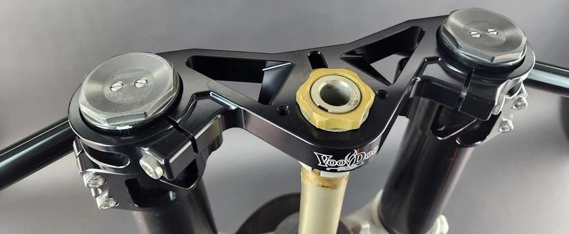 VooDoo Motorcycle Components Voodoo Top Triple Clamp Suzuki GSXR1000 (09-25) Open Box, close-up image of motorcycle top triple clamp with black finish and gold steering stem nut.