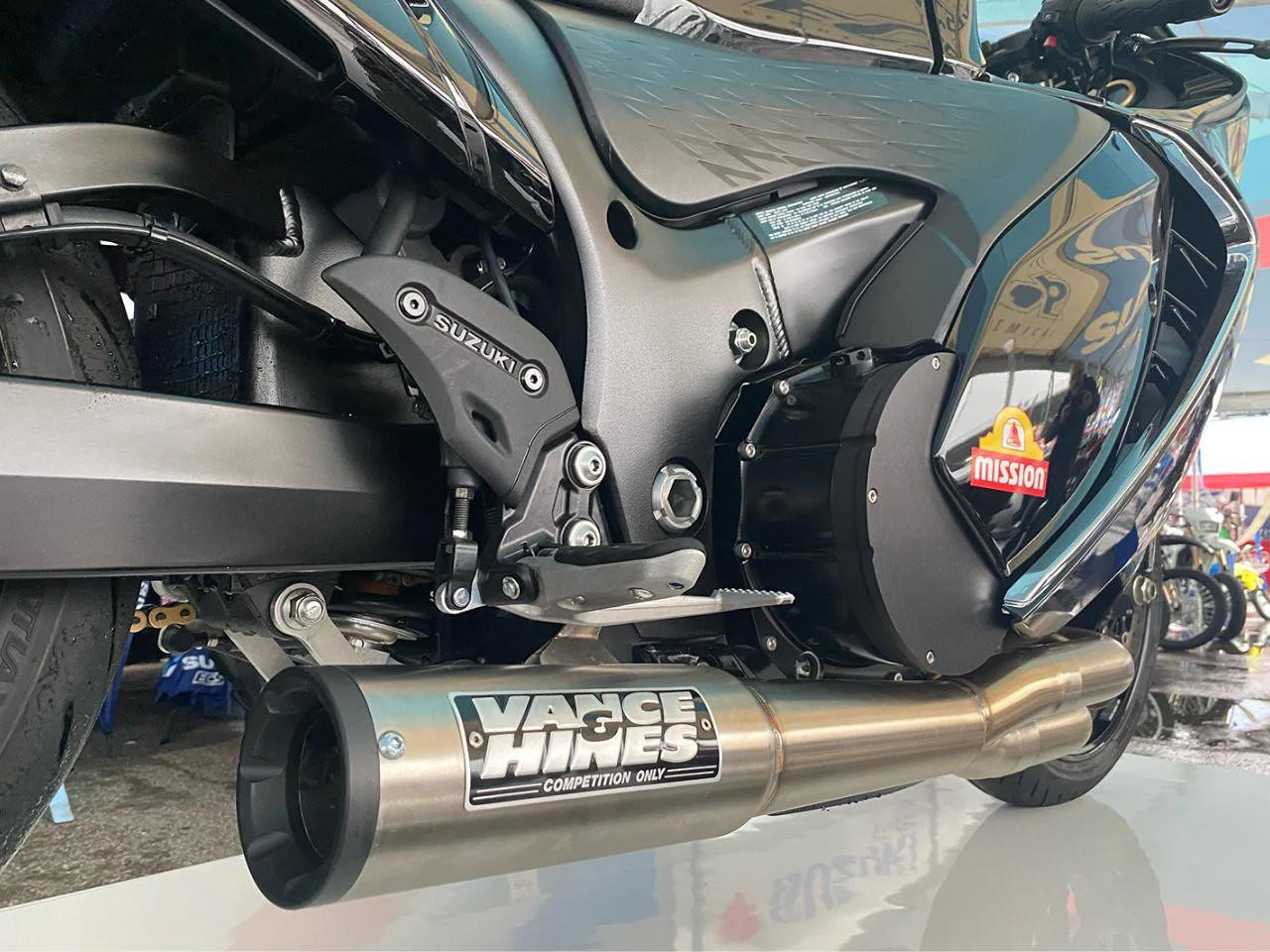 Vance & Hines Sidewinder Exhaust Suzuki Hayabusa (99-26), a close-up view of the aftermarket exhaust system installed on a Suzuki Hayabusa motorcycle, showcasing the dual pipes and branding. Vance & Hines Sidewinder Exhaust Suzuki Hayabusa (99-26), a close-up view of the aftermarket exhaust system installed on a Suzuki Hayabusa motorcycle, showcasing the dual pipes and branding.