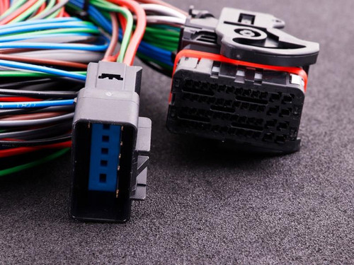 MaxxECU V1/Race/Pro Flying Lead Wiring Harness Connector, close-up view of wiring harness with multiple colored wires and connectors on a dark surface.