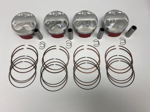 Wossner Piston Kit Suzuki GSXR1000 (17-25), including four pistons with pins and multiple rings and recoil springs laid out for engine repair or replacement.