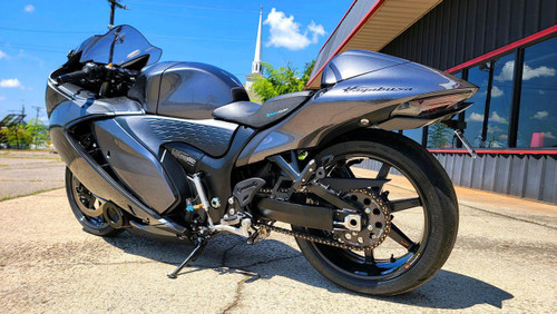 CeraCarbon Hybrid Rear Sprocket Suzuki Hayabusa (08-25), close-up view of the black and silver sprocket on a sleek gray motorcycle in daylight.