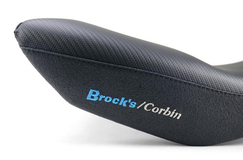 Brocks Performance Custom Corbin Seat BMW S1000RR (12-19) HP4 (12-15), close-up view of the black motorcycle seat with textured top and embroidered blue and white logo. Brocks Performance Custom Corbin Seat BMW S1000RR (12-19) HP4 (12-15), close-up view of the black motorcycle seat with textured top and embroidered blue and white logo.