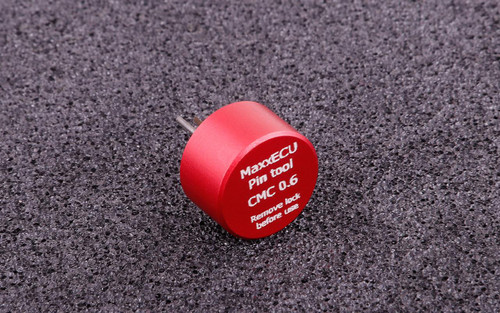 MaxxECU CMC 0.6 Terminal Removal Tool, small red cylindrical pin tool on a black textured surface. MaxxECU CMC 0.6 Terminal Removal Tool, small red cylindrical pin tool on a black textured surface.