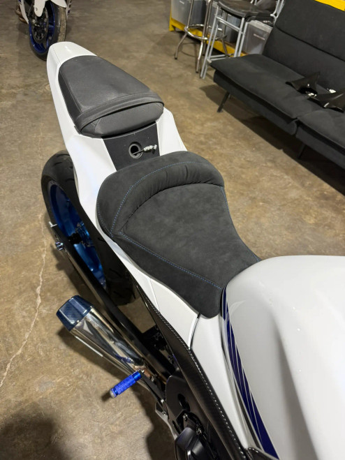 Schnitz Racing Motorcycle Performance Parts Alcantara Cut Seat GSXR1000 (17-25), black Alcantara motorcycle seat with blue stitching for GSXR1000 models from 2017 to 2025.