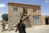  U.S soldiers evacuating a worn stucco house