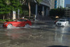 cars pass through a partially flooded street