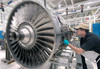 Man intently works on repairing airplane engine, industrial setting 