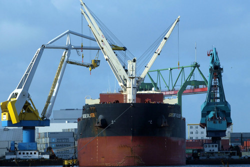 large boat on water with construction cranes 