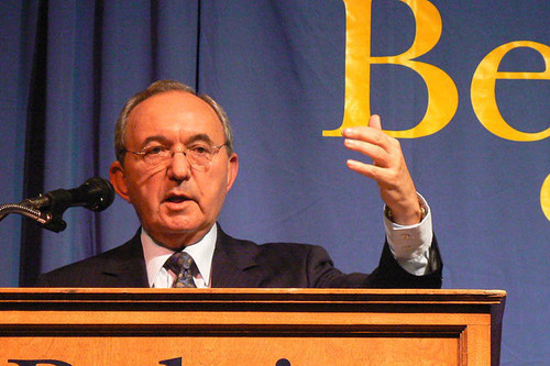 man addresses audience on podium 