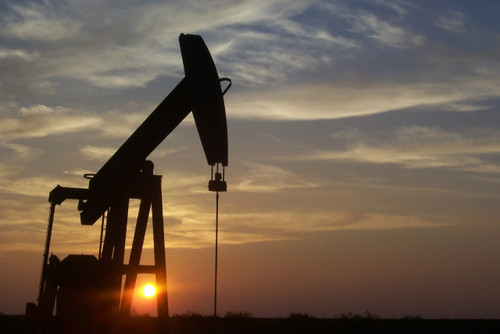 machine drills for oil at sunset 