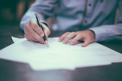 man in dress shirt writing