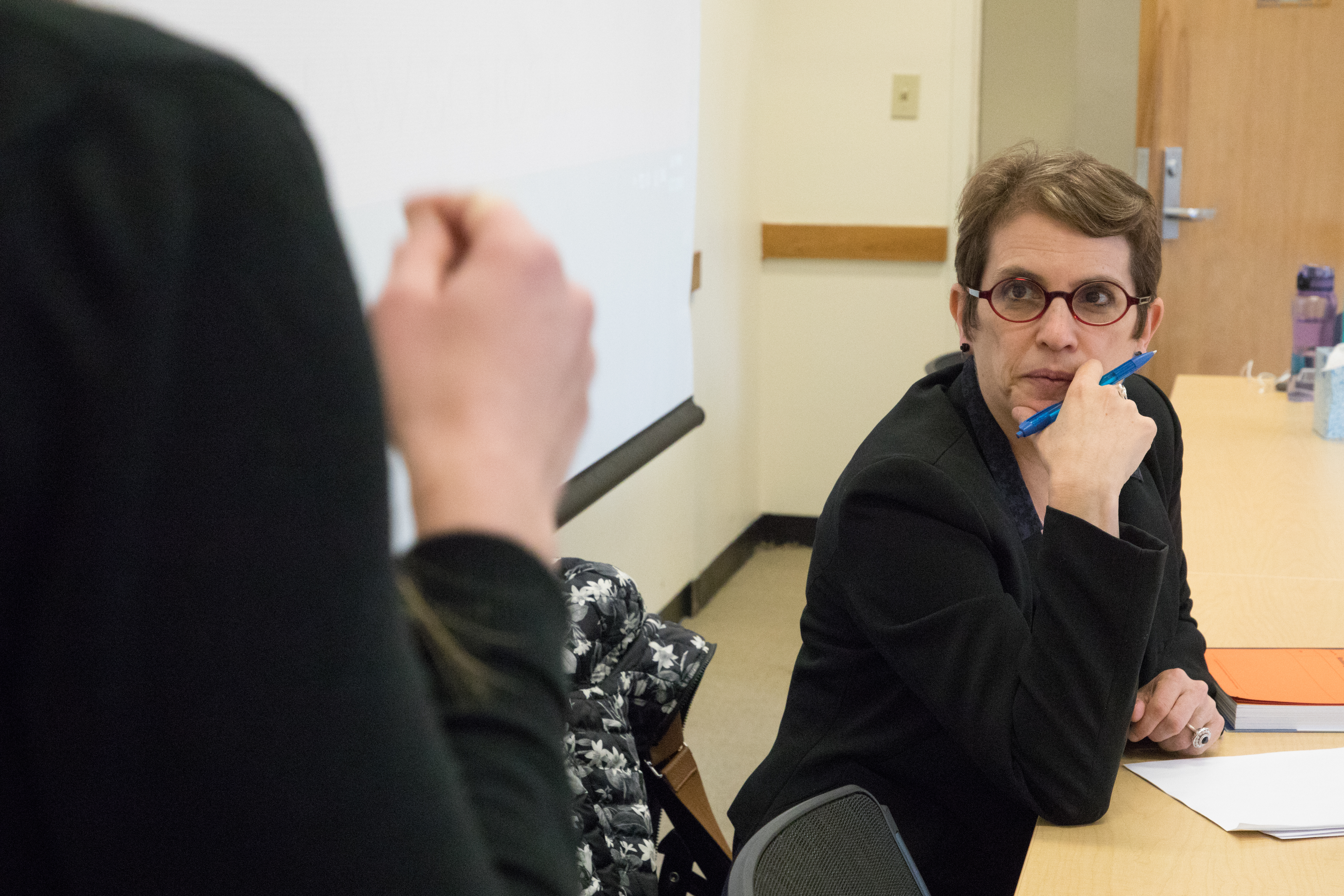 Professor Sharon Block listening to a student at her desk