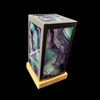 Rainbow fluorite lantern lamp glowing under UV blacklight, fluorescent purple green, black metal frame