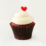 Traditional southern-style red velvet cake and cream cheese icing topped with a little red fondant heart