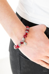A collection of red crystal-like beads and ornate silver beads are threaded along a stretchy band around the wrist. An abstract silver heart charm swings from the center, for a romantic finish. A collection of red crystal-like beads and ornate silver beads are threaded along a stretchy band around the wrist. An abstract silver heart charm swings from the center, for a romantic finish.