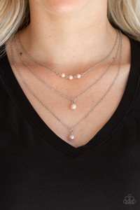 A trio of pearly pink beads give way to layers of solitaire pink pearl pendants below the collar for a refined flair. Features an adjustable clasp closure.
Sold as one individual necklace. Includes one pair of matching earrings. A trio of pearly pink beads give way to layers of solitaire pink pearl pendants below the collar for a refined flair. Features an adjustable clasp closure.
Sold as one individual necklace. Includes one pair of matching earrings.