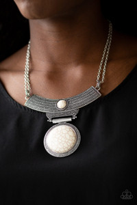 An antiqued silver plate, adorned in rippling circular textures, swings from the bottom of a pair of doubled silver chains. The ornate plate gives way to a dramatic white stone pendant bordered by tribal inspired patterns for a statement-making finish. Features an adjustable clasp closure.
Sold as one individual necklace. Includes one pair of matching earrings. An antiqued silver plate, adorned in rippling circular textures, swings from the bottom of a pair of doubled silver chains. The ornate plate gives way to a dramatic white stone pendant bordered by tribal inspired patterns for a statement-making finish. Features an adjustable clasp closure.
Sold as one individual necklace. Includes one pair of matching earrings.