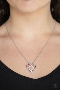 A red rhinestone encrusted heart intertwines with two plain silver heart frames, stacking into a romantic pendant at the bottom of a sleek silver chain. Features an adjustable clasp closure.

Sold as one individual necklace. Includes one pair of matching earrings.