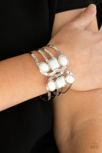 Dotted with oval and square white beads, hammered silver bars asymmetrically connect into two scalloped silver frames around the wrist, creating an adjustable open-faced cuff. Features a hinged closure.

Sold as one individual bracelet.