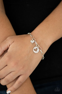 As if cut out from the white rhinestone encrusted disc, a glittery heart charm swings alongside a matching heart charm along a chunky silver chain around the wrist for a flirtatious look. Features an adjustable clasp closure.
Sold as one individual bracelet. As if cut out from the white rhinestone encrusted disc, a glittery heart charm swings alongside a matching heart charm along a chunky silver chain around the wrist for a flirtatious look. Features an adjustable clasp closure.
Sold as one individual bracelet.