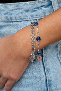 Infused with dainty silver bars, a charming collection of heart-shaped blue cat's eye stone beads delicately connect around the wrist alongside two silver chains of a whimsically layered look. Features an adjustable clasp closure.

Sold as one individual bracelet.