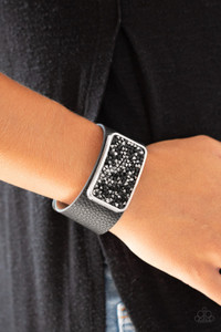 A collision of black and hematite rhinestones collect inside a silver rectangular frame that is studded in place in the center of a thick black leather band, creating a sparkling statement piece around the wrist. Features an adjustable snap closure.
Sold as one individual bracelet. A collision of black and hematite rhinestones collect inside a silver rectangular frame that is studded in place in the center of a thick black leather band, creating a sparkling statement piece around the wrist. Features an adjustable snap closure.
Sold as one individual bracelet.