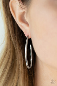 Delicately hammered in shimmery textures, a shiny silver bar curves into an asymmetrical hook-like hoop for an edgy look. Earring attaches to a standard post fitting. Hoop measures approximately 1" in diameter.

Sold as one pair of hoop earrings.