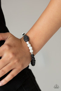 A collection of silver beads, black lava rock, and white lava rock beads are threaded along a stretchy band around the wrist for a seasonal look.

Sold as one individual bracelet.