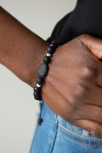 Infused with dainty silver accents, a collection of black lava rock beads are threaded along a shiny black cord around the wrist for a seasonal look.

Features an adjustable sliding knot closure.
