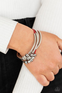 Multiple strands of red cord are fitted with long, curved cylinders that meet in the middle. The sliding bars are separated by small antiqued silver loops that mimic pipe fittings, making this a perfect addition to any industrial look. Features an adjustable clasp closure. Multiple strands of red cord are fitted with long, curved cylinders that meet in the middle. The sliding bars are separated by small antiqued silver loops that mimic pipe fittings, making this a perfect addition to any industrial look. Features an adjustable clasp closure.