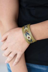 Blue, brown, and white thread is stitched across the front of a Willow leather band, creating a colorful tribal inspired pattern. Features an adjustable snap closure.

Sold as one individual bracelet.