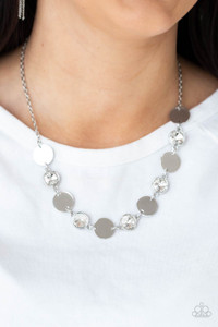 Shiny silver discs and oversized glassy white gems delicately link below the collar, creating a sparkly statement piece. Features an adjustable clasp closure.

Sold as one individual necklace. Includes one pair of matching earrings.