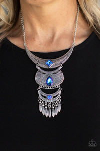 Embossed in studded, geometric, and paisley filigree-like patterns, three mismatched silver half moon plates dramatically link below the collar. Featuring an entrancing blue UV shimmer, an oversized collection of square, teardrop, and round rhinestones embellish the decorative silver frames, while a silver beaded fringe swings from the lowermost plate for a noisemaking finish. Features an adjustable clasp closure.
Sold as one individual necklace. Includes one pair of matching earrings. Embossed in studded, geometric, and paisley filigree-like patterns, three mismatched silver half moon plates dramatically link below the collar. Featuring an entrancing blue UV shimmer, an oversized collection of square, teardrop, and round rhinestones embellish the decorative silver frames, while a silver beaded fringe swings from the lowermost plate for a noisemaking finish. Features an adjustable clasp closure.
Sold as one individual necklace. Includes one pair of matching earrings.