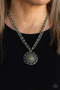 A dainty silver chain is paired with a grounding green stone beaded chain below the collar. An oversized green stone adorns the center of an antiqued silver frame radiating with silver studded and wire-like detail, creating an authentic artisan inspired pendant at the bottom of the earthy chains. Features an adjustable clasp closure.

Sold as one individual necklace. Includes one pair of matching earrings.