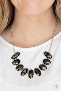 Generous glossy black gems, dusted in shimmery gold, lay in silver oval frames and link across the collar creating a glimmering statement. Features an adjustable clasp closure.

Sold as one individual necklace. Includes one pair of matching earrings.