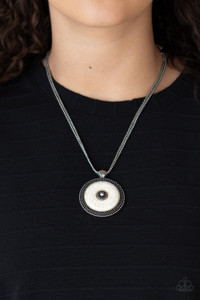 A smooth white stone disc is pressed into a textured silver frame radiating with rings of silver studs, creating a rustic medallion below the collar. Features an adjustable clasp closure.
Sold as one individual necklace. Includes one pair of matching earrings. A smooth white stone disc is pressed into a textured silver frame radiating with rings of silver studs, creating a rustic medallion below the collar. Features an adjustable clasp closure.
Sold as one individual necklace. Includes one pair of matching earrings.