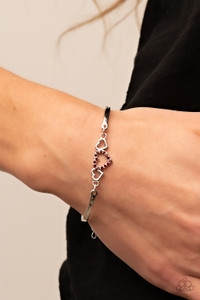 Two shiny silver hearts flank a red rhinestone dotted heart at the center of two curved silver bars, linking into a flirtatious centerpiece around the wrist. Features an adjustable clasp closure.
Sold as one individual bracelet. Two shiny silver hearts flank a red rhinestone dotted heart at the center of two curved silver bars, linking into a flirtatious centerpiece around the wrist. Features an adjustable clasp closure.
Sold as one individual bracelet.