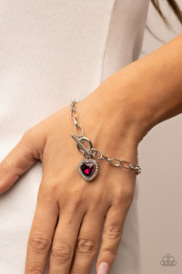 Bordered in glassy white rhinestones, a pink heart shaped gem sparkles from a toggle closure at the center of an oval silver linked chain for a flirtatious fashion around the wrist. Features a toggle closure.
Sold as one individual bracelet. Bordered in glassy white rhinestones, a pink heart shaped gem sparkles from a toggle closure at the center of an oval silver linked chain for a flirtatious fashion around the wrist. Features a toggle closure.
Sold as one individual bracelet.